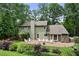 Exterior view of home, showing backyard with brick patio, lush lawn and garden with mature trees at 300 Stone Mill Trl, Atlanta, GA 30328