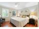 Cozy bedroom featuring a queen-sized bed, two windows, and hardwood floors with an accent chair at 300 Stone Mill Trl, Atlanta, GA 30328