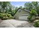 Home with a two-car garage, concrete driveway and mature trees providing shade, curb appeal, and functionality at 300 Stone Mill Trl, Atlanta, GA 30328