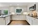 Bright kitchen featuring white cabinets, stainless steel appliances, and dark countertops with natural lighting at 300 Stone Mill Trl, Atlanta, GA 30328