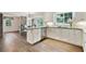 Bright kitchen features white cabinetry, stainless steel appliances, and a dark countertop island with wood flooring at 300 Stone Mill Trl, Atlanta, GA 30328
