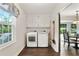 Laundry room features a washer and dryer, a window, upper cabinets, and access to the kitchen dining area at 300 Stone Mill Trl, Atlanta, GA 30328