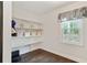 Unfinished storage room featuring open shelves, a window, and hardwood floors with neutral-colored walls at 300 Stone Mill Trl, Atlanta, GA 30328