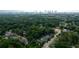 An aerial view of residential streets surrounded by dense trees with the city skyline visible in the background at 1232 Lucile Sw Ave, Atlanta, GA 30310