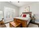 Cozy bedroom featuring a wooden bed frame, hardwood floors, and a chest at the foot of the bed at 1232 Lucile Sw Ave, Atlanta, GA 30310