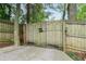 Automated driveway gate with wood fencing and mature trees at 1232 Lucile Sw Ave, Atlanta, GA 30310