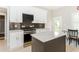 A well-lit kitchen with a black backsplash, island, stainless steel range and stainless steel appliances at 1232 Lucile Sw Ave, Atlanta, GA 30310