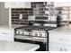 The kitchen features a stainless steel gas stove with sleek black backsplash and white countertops at 1232 Lucile Sw Ave, Atlanta, GA 30310