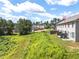 View of the back of the townhomes featuring a lush backyard and a small patio area with blue chairs at 5843 Taka Ln, Lithonia, GA 30038