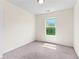 Cozy bedroom with natural light, plush carpeting, and a view of the trees through the window at 5843 Taka Ln, Lithonia, GA 30038