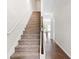 Bright, carpeted staircase with white walls, wooden banister and hardwood flooring at 5843 Taka Ln, Lithonia, GA 30038