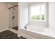 Bathroom featuring a glass-enclosed shower and a soaking tub by a window, offering a spa-like experience at 1731 Fulmont Cir, Mableton, GA 30126