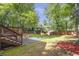 Expansive backyard featuring a wooden deck with stairs down to a fire pit area and surrounded by lush landscaping at 410 Sheringham Ct, Roswell, GA 30076