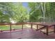Inviting backyard with a wooden deck, mature trees, and fenced perimeter, perfect for relaxing and outdoor activities at 410 Sheringham Ct, Roswell, GA 30076