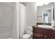 Bright bathroom featuring a shower-tub combo with white marble tiling and a granite-topped vanity at 410 Sheringham Ct, Roswell, GA 30076