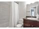 Bright bathroom featuring a shower-tub combo with modern white marbled tile surround, dark wood vanity, and neutral walls at 410 Sheringham Ct, Roswell, GA 30076