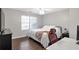 This bedroom features wood floors, a ceiling fan, and natural light from the window at 410 Sheringham Ct, Roswell, GA 30076
