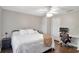 Comfortable bedroom featuring a ceiling fan, natural light, and a desk area at 410 Sheringham Ct, Roswell, GA 30076