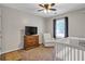 This bedroom has a ceiling fan, a chair, and a crib for a modern Bedroom at 410 Sheringham Ct, Roswell, GA 30076