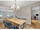 This dining room includes a modern chandelier and a view into the living room and office space at 410 Sheringham Ct, Roswell, GA 30076