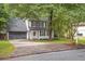 Traditional home with a gray garage door, black shutters, white siding, and a well-maintained lawn at 410 Sheringham Ct, Roswell, GA 30076