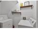 Bright laundry room features shiplap walls and shelving above the washer and dryer at 410 Sheringham Ct, Roswell, GA 30076