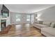 Bright living room featuring a decorative fireplace, large windows and hardwood floors at 410 Sheringham Ct, Roswell, GA 30076