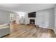 Open-concept living room featuring hardwood floors, a fireplace, and ample natural light at 410 Sheringham Ct, Roswell, GA 30076