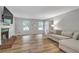 Bright living room featuring hardwood floors, a fireplace, and large windows at 410 Sheringham Ct, Roswell, GA 30076