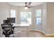This bright and sunny office space features a ceiling fan and multiple windows overlooking the backyard at 410 Sheringham Ct, Roswell, GA 30076