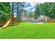 Expansive backyard features a pristine pool, play set, and lush green lawn, creating an ideal outdoor living space at 440 Junction Trak, Roswell, GA 30075