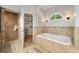 Elegant bathroom showcasing walk-in shower, soaking tub, tile floors, and adjoining walk-in closet at 440 Junction Trak, Roswell, GA 30075
