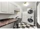 Practical laundry room with a stacked washer/dryer, sink, and checkerboard flooring at 440 Junction Trak, Roswell, GA 30075