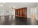 Spacious living room with a ceiling fan, hardwood floors, and a built-in wooden bookcase at 440 Junction Trak, Roswell, GA 30075