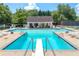 Community pool featuring a diving board, lounge chairs, umbrellas, and a tennis court, enhancing resort-style living at 440 Junction Trak, Roswell, GA 30075