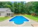 Backyard pool is surrounded by a concrete patio, wooden fence, and green lawn perfect for outdoor relaxation and play at 440 Junction Trak, Roswell, GA 30075