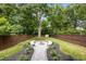 Landscaped backyard with a fire pit and stone bench seating surrounded by lush greenery at 1102 Sanders Se Ave, Atlanta, GA 30316
