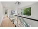 Upstairs hallway with glass railings, a modern chandelier, and large windows offering scenic views at 1102 Sanders Se Ave, Atlanta, GA 30316