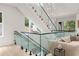 Modern staircase with glass railings, wood steps, and bright light from large windows at 1102 Sanders Se Ave, Atlanta, GA 30316