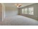Large bedroom with plush carpeting, multiple windows, and a ceiling fan for year-round comfort at 568 Teversham Dr, Mcdonough, GA 30253