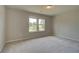 Cozy bedroom featuring neutral carpet, two large windows for natural light, and soothing neutral walls at 568 Teversham Dr, Mcdonough, GA 30253