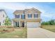 Charming two-story home with a manicured lawn and attached two-car garage at 568 Teversham Dr, Mcdonough, GA 30253