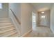 Open foyer with light hardwood floors, a staircase, and an entry to another room at 568 Teversham Dr, Mcdonough, GA 30253