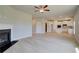 Open-concept living room with a fireplace, ceiling fan, and seamless flow into the modern kitchen at 568 Teversham Dr, Mcdonough, GA 30253