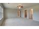 Spacious living room with a ceiling fan, carpeted floor, and neutral paint at 568 Teversham Dr, Mcdonough, GA 30253