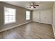 Spacious bedroom with wood-look flooring, two windows, and ample closet space at 1236 Pinedale Nw Cir, Conyers, GA 30012
