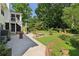 Backyard featuring a well-manicured lawn, brick fire pit, patio, and mature trees at 4046 Water Hole Ct, Douglasville, GA 30135