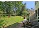 Expansive backyard featuring a lush lawn, manicured landscaping, and a charming patio area at 4046 Water Hole Ct, Douglasville, GA 30135