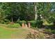 Landscaped backyard with a stone pathway leading through lush greenery at 4046 Water Hole Ct, Douglasville, GA 30135
