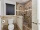 Bathroom featuring designer tile, glass enclosed shower, and toilet with dark wood accents at 4046 Water Hole Ct, Douglasville, GA 30135